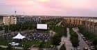 Evento al aire libre con pantalla de cine y público sentado en el parque Founders' Green