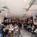 Interior del local con clientes comiendo y ambiente acogedor