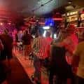 Interior animado del bar con clientes y ambiente festivo