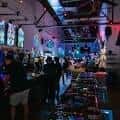 Ambiente festivo en el bar con clientes jugando y decoraciones luminosas