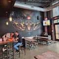 Interior del taproom con murales artísticos y mesas de madera