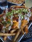 Plato de papas fritas con toppings en el Element Gastropub