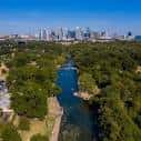 Vista aérea del Greenbelt de Barton Creek con el horizonte de Austin al fondo