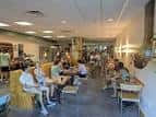 Interior del Bike Library Cafe con clientes sentados en mesas y ambiente acogedor