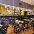 Área de comedor moderno en Gravy Raleigh con barra de bebidas y mobiliario contemporáneo