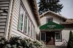 Entrada frontal del edificio con marquesina verde y detalles arquitectónicos