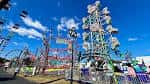 Atracción de montaña rusa y torre giratoria bajo cielo azul en el State Fair
