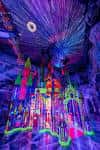 Escena interior colorida con estructuras futuristas y efectos lumínicos en Meow Wolf Denver