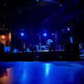 Escenario del club The Bottleneck con iluminación azul y ambiente nocturno