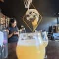 Interior acogedor de Brujos Brewing con barra y decoración temática