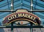 Detalle del letrero histórico 'City Market' bajo una estructura de vidrio y metal