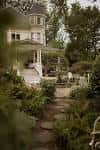 Jardín trasero de la mansión Victorian Belle con sendero y vegetación exuberante