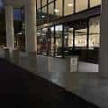 Fachada moderna de la biblioteca con grandes ventanales y columnas blancas en horario nocturno