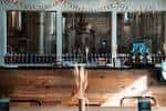 Interior del bar o sala de degustación con mostrador de madera y estantería de botellas al fondo