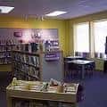 Interior de la biblioteca con estanterías y zona de lectura