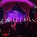 Concierto en vivo en el interior del Star Theater con luces de escenario y público animado