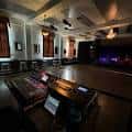 Interior del salón principal con escenario, iluminación profesional y zona de control de sonido