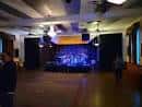 Escenario con banda en vivo bajo luces de concierto azules y moradas