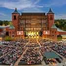 Concierto en vivo en el Starlight Theatre con multitud de espectadores bajo las luces del escenario