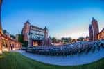 Vista panorámica del Starlight Theatre al atardecer con el escenario iluminado y butacas vacías
