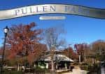 Entrada principal de Pullen Park con arco y letrero bajo cielo azul