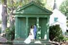 Pareja en su boda frente al pabellón verde clásico del parque