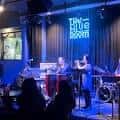 Escenario del Blue Room con banda en vivo y letrero de neón azul
