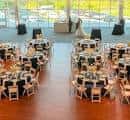 Interior del salón principal decorado para una boda con mesas redondas y novias en el fondo