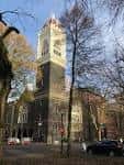 Fachada lateral de la iglesia en un día soleado con árboles alrededor