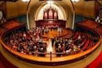 Evento musical en el interior de la iglesia con orquesta y público sentado