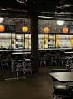 Interior del bar con mesas y sillas en ambiente acogedor