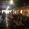 Interior del bar con clientes y barra de madera