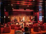 Interior del club con escenario y butacas rojas