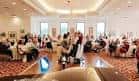 Sala de eventos con mesas redondas y asistentes sentados durante una reunión