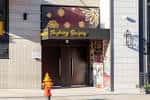 Fachada exterior del local Pushing Daisies con letrero iluminado