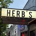 Letrero luminoso de 'HERB'S' en la fachada del local
