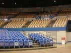 Interior del auditorio con butacas azules y amarillas dispuestas en gradas, listo para eventos