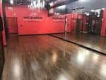 Interior del estudio de baile con paredes rojas y piso de madera