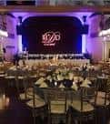 Interior del Madrid Theatre configurado para evento con mesas redondas y escenario iluminado