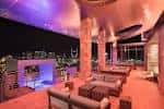 Interior del lounge con iluminación ambiental y vistas nocturnas de la ciudad