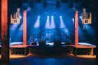 Escenario principal del Cannery Hall iluminado con luces azules y equipo de sonido