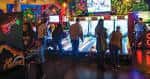 Zona de juegos arcade con personas jugando