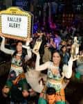 Interior animado con bailarinas y letrero 'Baller Alert' durante un evento nocturno