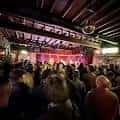 Interior del local lleno de gente durante un evento en vivo
