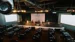 Escenario principal del venue con iluminación profesional y pantallas laterales