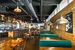 Área de bar y zona de asientos tipo banqueta en el interior del local
