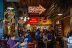 Interior del restaurante con ambiente rústico y clientes comiendo