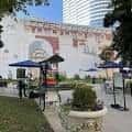 Escena real del Church Street Park con toldos, personas y murales en la pared