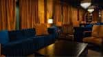 Interior acogedor del 1865 Club con sofás azules y cortinas doradas
