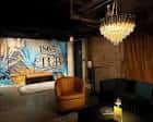 Área de lounge del club con lámpara de araña y murales decorativos